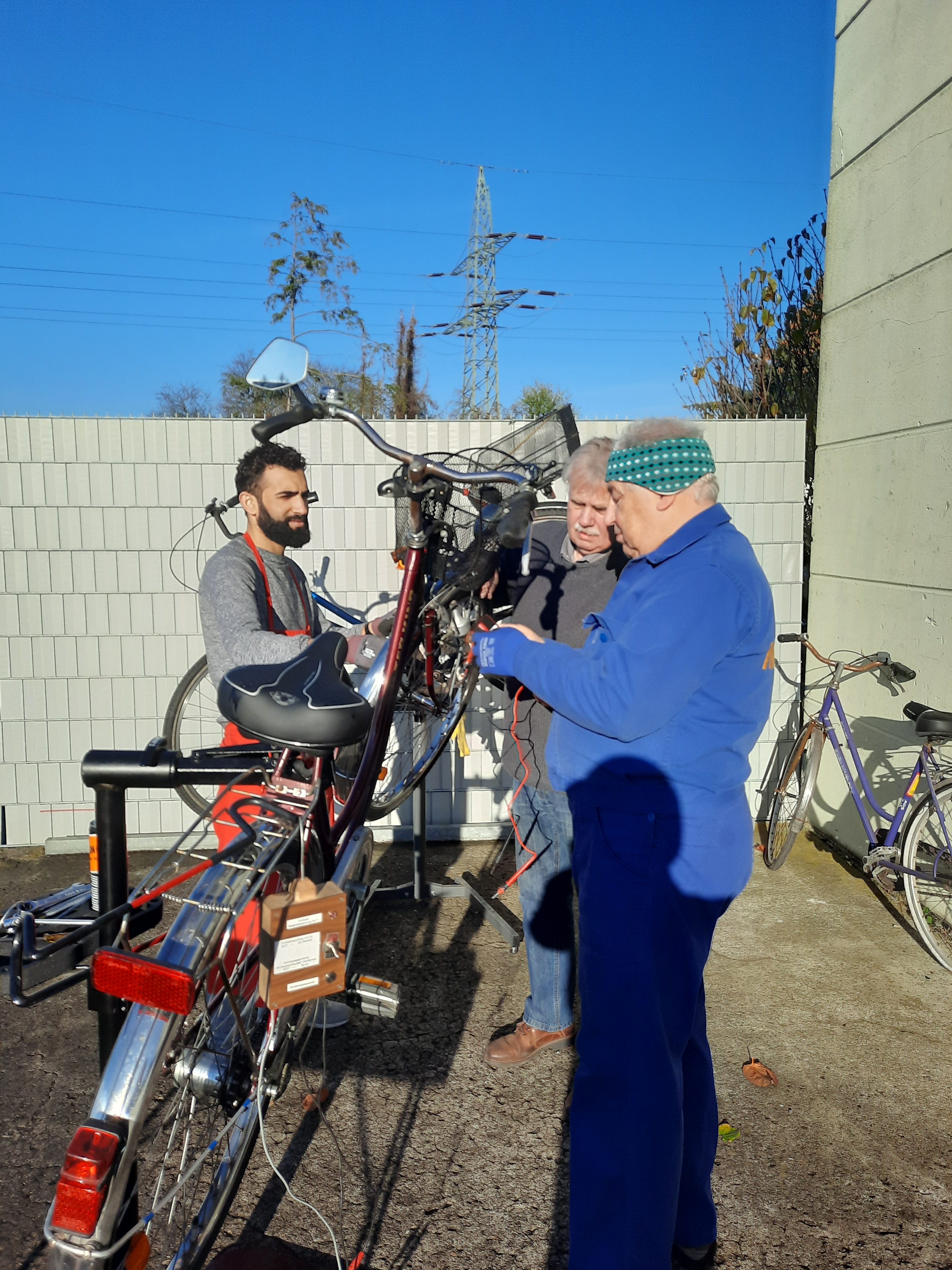 Ehrenamtliche aus der Fahrradwerkstatt reparieren ein Fahrrad